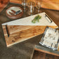 Woodland Bear Cutting Board from Wild Wings features a rustic two-tone design with wood and marble, black handles, and an engraved bear detail.